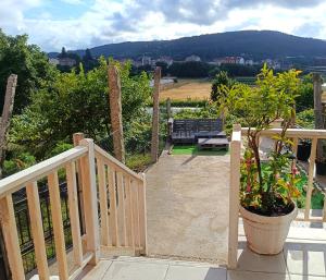 a wooden staircase with a potted plant on a balcony at Aldea de Rosalía in Padrón