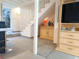 a living room with a television and a staircase at Aldea de Rosalía in Padrón