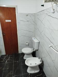 a bathroom with two toilets and a door at Villa Coca -Los Jilgueros- in Villa la Bolsa +16 photos