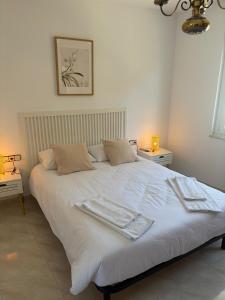 a white bed with two towels on top of it at A Casa do Miradoiro in Puentedeume