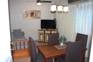 a dining room with a table and a television at MRU Colón aparts in Colón