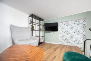 a living room with a table and a chair at S-HE Space - Budget Micro Rooms Kraków in Krakow