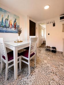 a dining room with a white table and chairs at Romantic Mirka Apartment in Sremski Karlovci in Sremski Karlovci