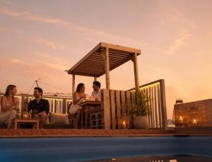 a group of people sitting at a table by a pool at DAR-VIDA Guesthouse in Imsouane