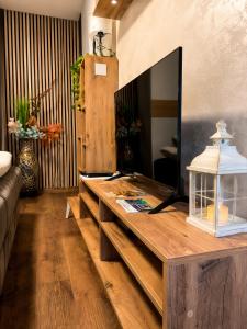 a living room with a wooden table and a tv at Romantic Mirka Apartment in Sremski Karlovci in Sremski Karlovci