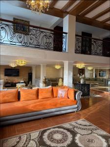 an orange couch in a living room with a kitchen at Tanger Achakar in Tangier