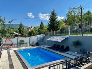a swimming pool on a patio with chairs around it at Azure Pool Residence in Sarajevo