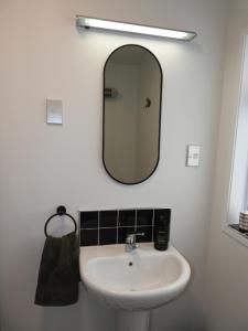 a bathroom with a sink and a mirror at Stirling St Surf Villa in Dunedin +8 photos