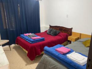 a bedroom with two beds with red and blue blankets at Casa los Churumbeles in Potrerillos