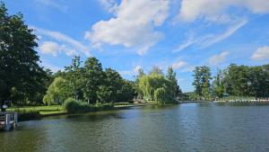 a view of a river in a park with trees at Pension Miss Sophie in Kyritz