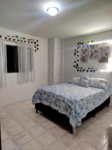 a bedroom with a bed with a blue comforter at DESTINY Apto Parque in San Rafael