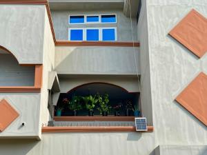 a building with a window with plants on it at Petit Cocon de Ouidah - Chambre Cosy Climatisée - Plage a 10 min - Salon, Cuisine et balcon in Ouidah