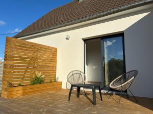 two chairs and a table on a deck at SPA La Maison du Bonheur Suite avec Spa prive pres d Arras in Roeux