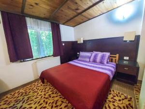 a bedroom with a bed with a red blanket and a window at Hotel Rimski Most in Sarajevo +77 photos