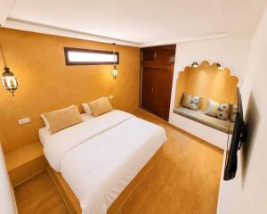 a bedroom with a large white bed and a bench at Dar-Vida Guesthouse in Imsouane +29 photos