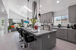 a kitchen with a large island with black chairs at Luxury New Build Bright 2BR 2BA Large Backyard in Mission Viejo
