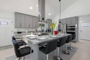 a kitchen with a large island with black chairs at Luxury New Build Bright 2BR 2BA Large Backyard in Mission Viejo