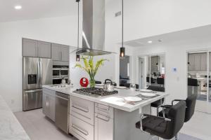 a white kitchen with a stove and a sink at Luxury New Build Bright 2BR 2BA Large Backyard in Mission Viejo