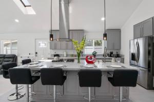 a kitchen with a large white island with black chairs at Luxury New Build Bright 2BR 2BA Large Backyard in Mission Viejo