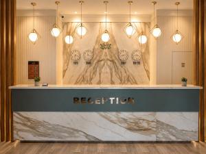 a lobby with a reception counter with clocks on the wall at Yeşilyurt Park Otel in Çorlu