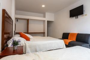 a hotel room with two beds and a couch at Costa Beach in Zorritos