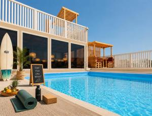 a swimming pool with a surfboard next to a building at Dar-Vida Guesthouse in Imsouane