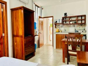 a kitchen with a wooden cabinet and a table at Suite Economy in Puerto Ayora