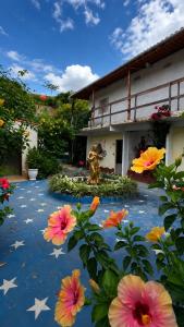 a garden with flowers in front of a building at Pousada das Estrelas - Centro de Conservatória - rua principal in Conservatória