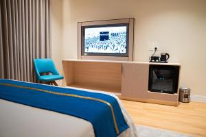 a hotel room with a bed and a television at شقق ركن تالا للشقق المفروشة - اقتصادي in Buraydah