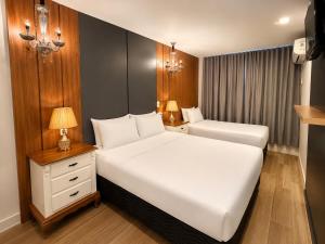 a bedroom with a large white bed and a night stand at Eleganz Suítes Exclusive Centro in Gramado +71 photos
