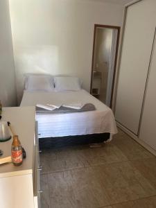 a bedroom with a bed with white sheets and pillows at Suite LUAR in Saquarema