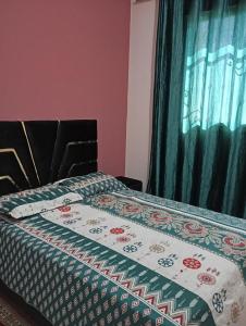 a bedroom with a bed with a quilt on it at Asrati in Ifrane
