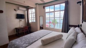 a bedroom with a large bed with a large window at Hotel Casa Amelia in Flores