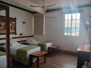 a hotel room with two beds and a window at Hotel Casa Amelia in Flores