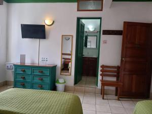 a bedroom with a bed and a dresser and a mirror at Hotel Casa Amelia in Flores