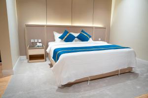 a bedroom with a large bed with blue pillows at شقق ركن تالا للشقق المفروشة - اقتصادي in Buraydah +28 photos