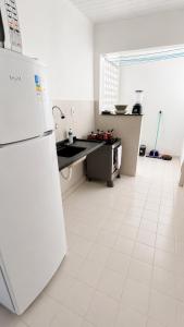 a white kitchen with a refrigerator and a sink at Apartamento em localização estratégica em Aracaju in Aracaju