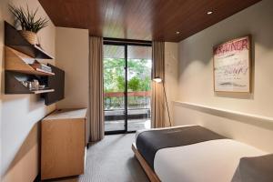 a bedroom with a bed and a large window at TRUNK(HOTEL)CAT STREET in Tokyo