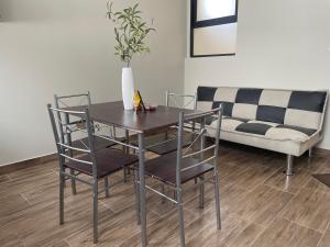 a dining room table with chairs and a couch at Olive Loft - Local Sensory and Boutique Experience in Tacna +1 photo