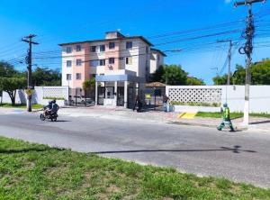 a person riding a motorcycle down a street at Apartamento em localização estratégica em Aracaju in Aracaju