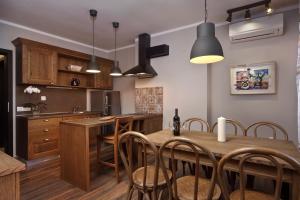 a kitchen with a wooden table and chairs at Esterra Vini Guest House in Perushtitsa