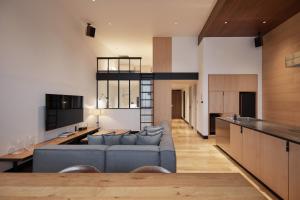 a living room and kitchen with a blue couch at TRUNK(HOTEL)CAT STREET in Tokyo