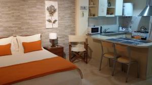 a bedroom with a bed and a small kitchen at Apart Avenida in Concordia