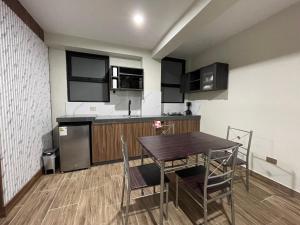 a kitchen with a table and chairs in a room at Olive Loft - Local Sensory and Boutique Experience in Tacna