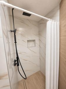 a shower in a bathroom with a shower curtain at Apartmani Morѐll in Novalja