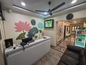 a lobby with a reception desk with flowers on the wall at Jay & Jas Hotel in Tirupati