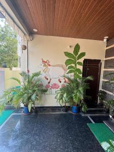 a wall with a painting of a chicken and potted plants at Jay & Jas Hotel in Tirupati +14 photos