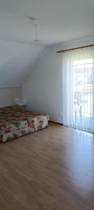 an empty room with a bed and a large window at Domki letniskowe "DORCIA" in Łeba