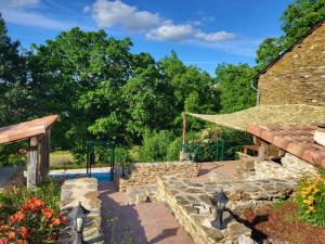 a garden with a stone building and a pool at Anaky rider nomade in Curvalle