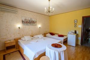 a bedroom with two beds and a table in it at Room Marta in Omišalj